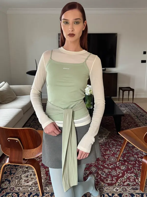 AI actor Elena in a layered sage outfit in a living room, from Pixraft Marketing Studio